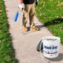 Applying Crack Stix 1/2 inch gray concrete joint filler on sidewalk with torch for permanent repair'