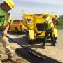 Crew using Falcon Asphalt Hot Box Trailer to repair potholes on road with hot mix asphalt'