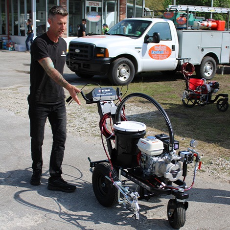 Man demonstrating line striping machine for pavement markings